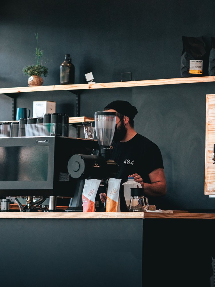 Barista de 404 trabajando detrás de la máquina de café